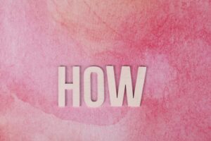 Pink watercolor background featuring the word 'HOW' in bold text for conceptual use.