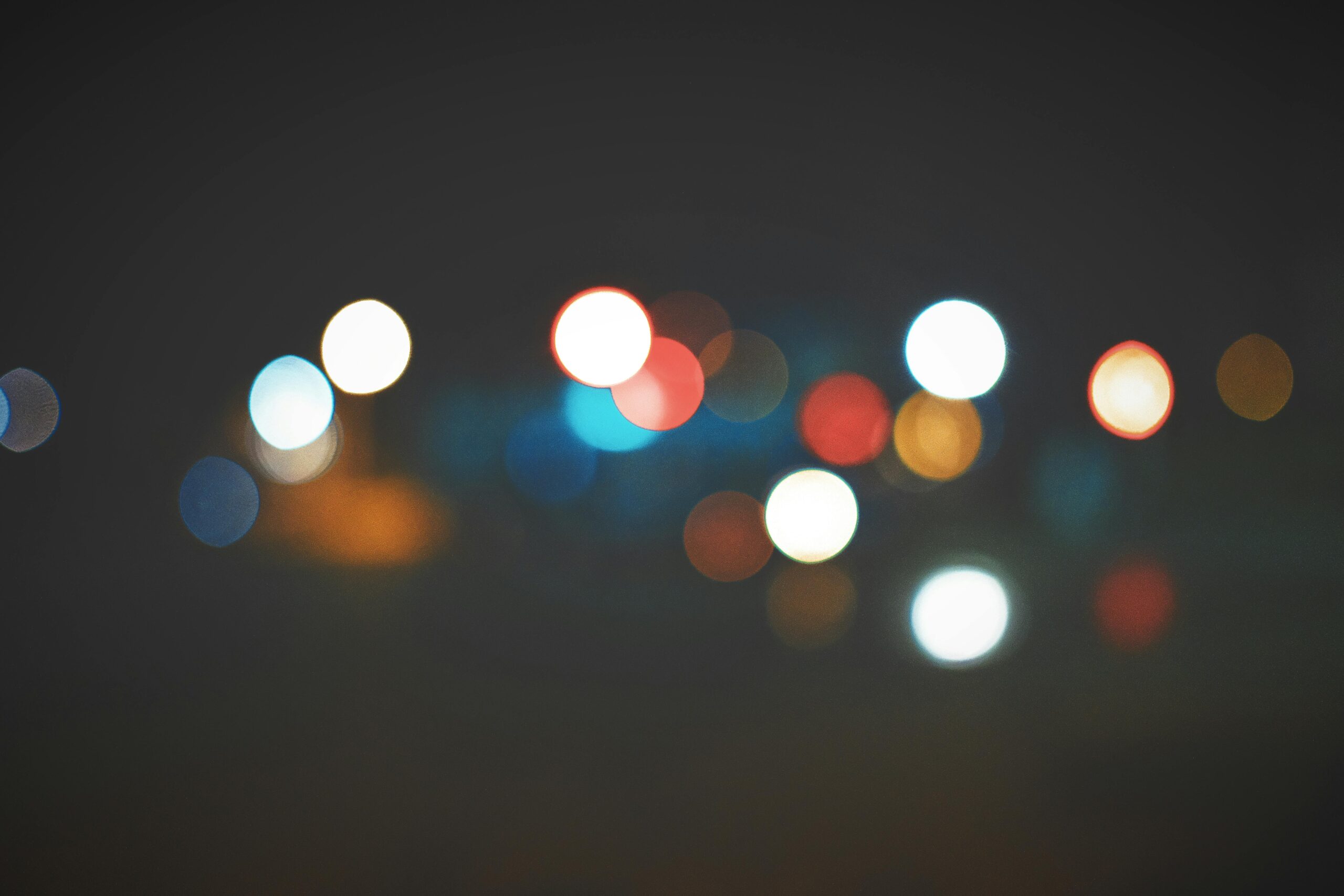 An artistic bokeh effect of colorful city lights creating a soft, dreamy atmosphere.